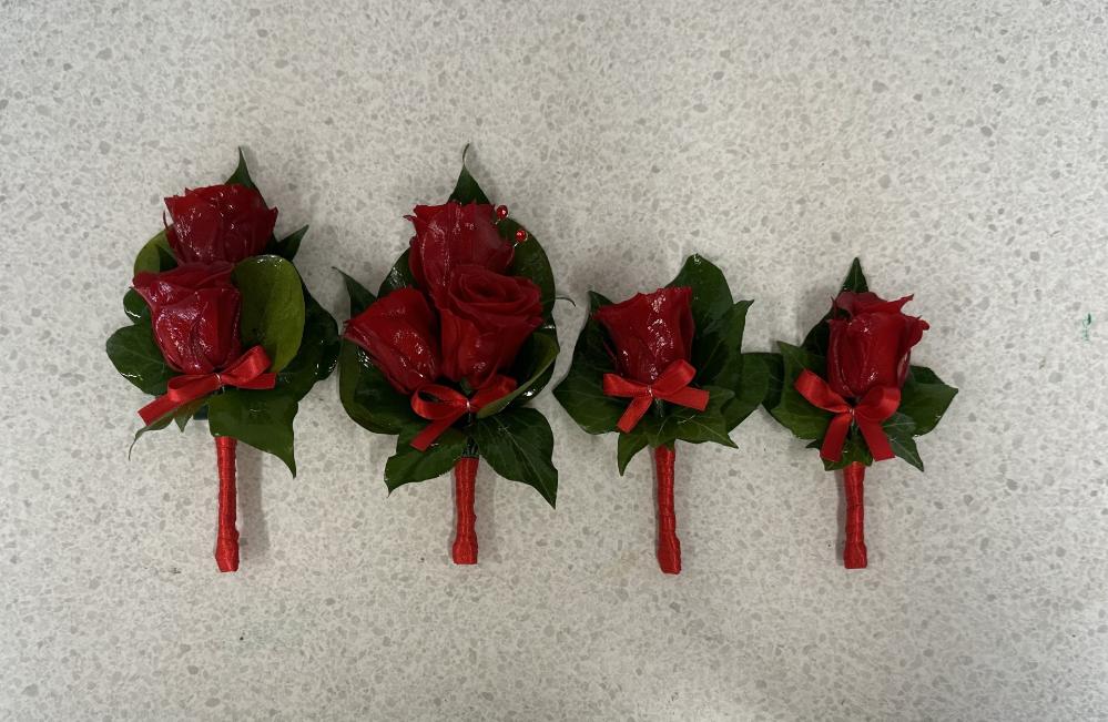 Set of matching red rose buttonholes for a family