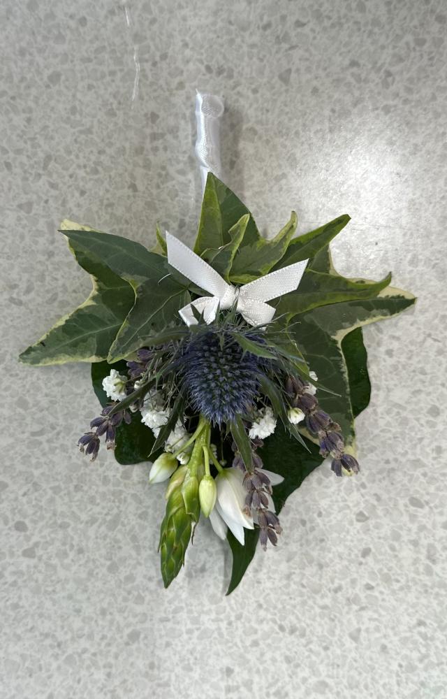 Ladies pinned corsage with fresh thistle, ornithogalum and gypsophila